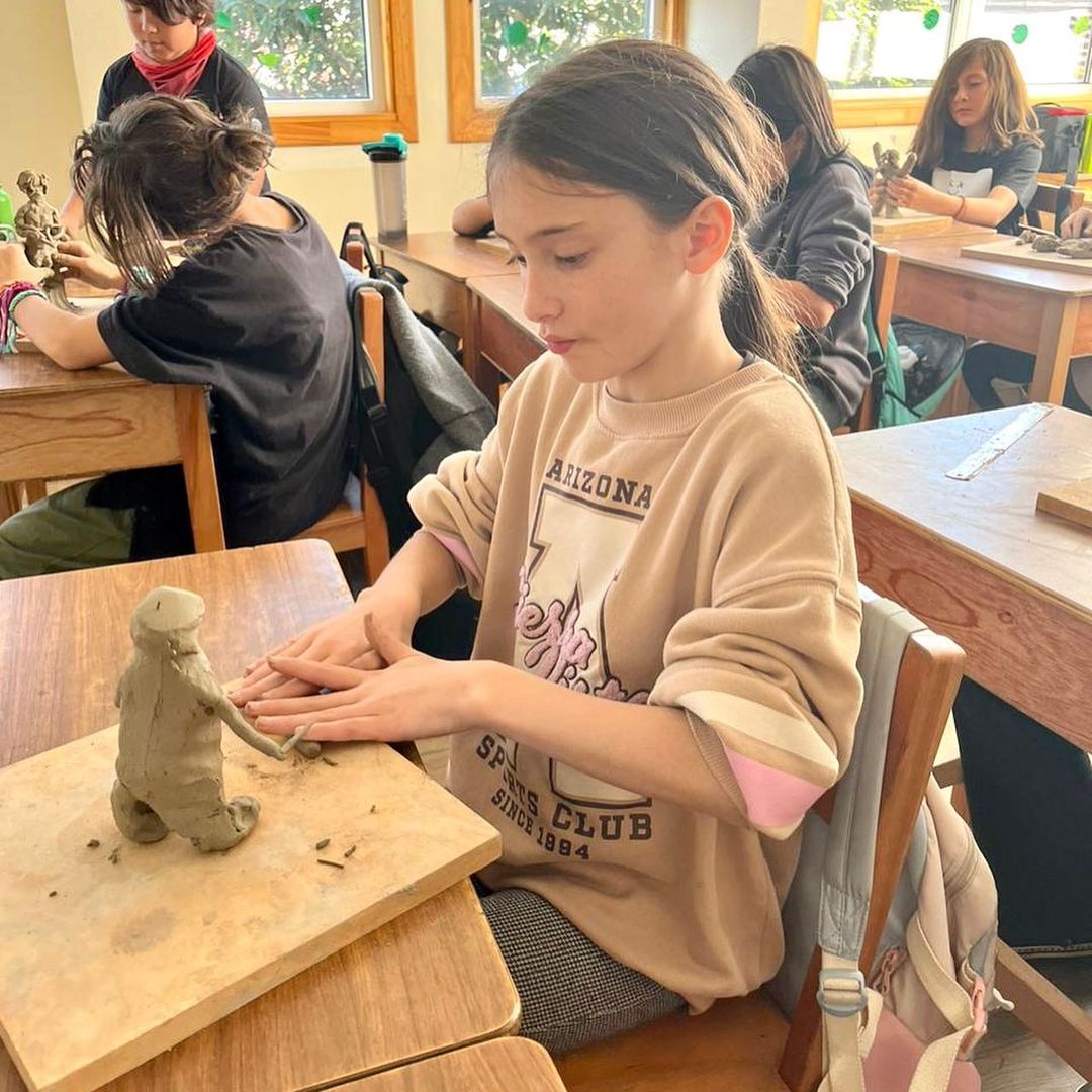 Niña modelando arcilla en la sala de clases