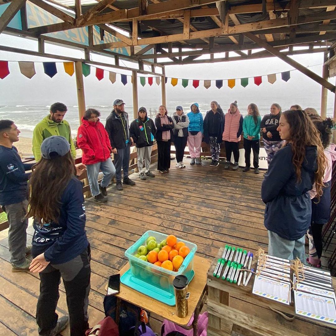 Comunidad escolar reunida bajo una terraza de madera con banderines