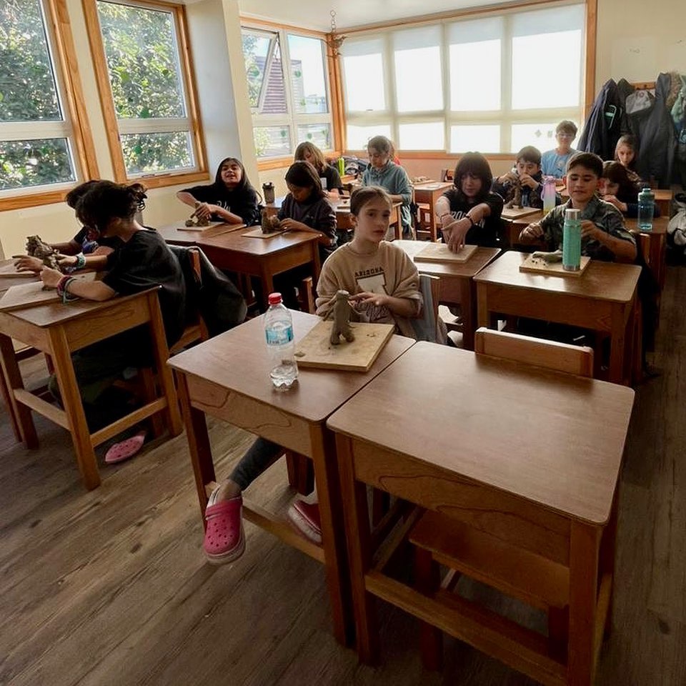Sala de clases con pupitres de madera y luz natural